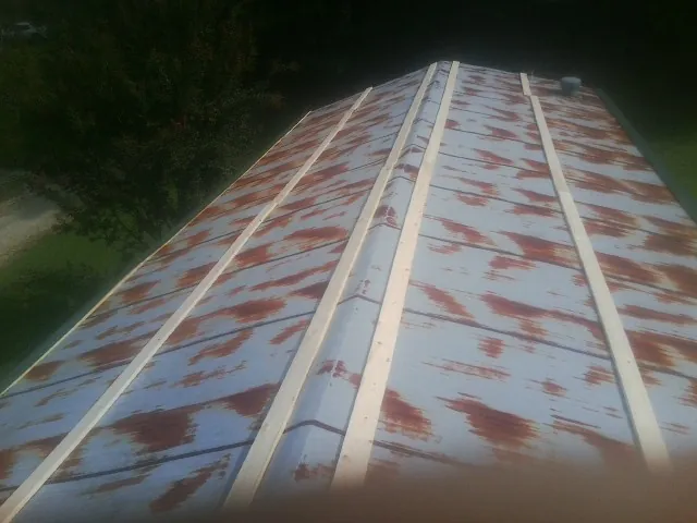 Rusted metal roof panels with new wood purlins before replacement — Storm Damage Roof Repair in Pope Army Airfield by Roofing Brothers