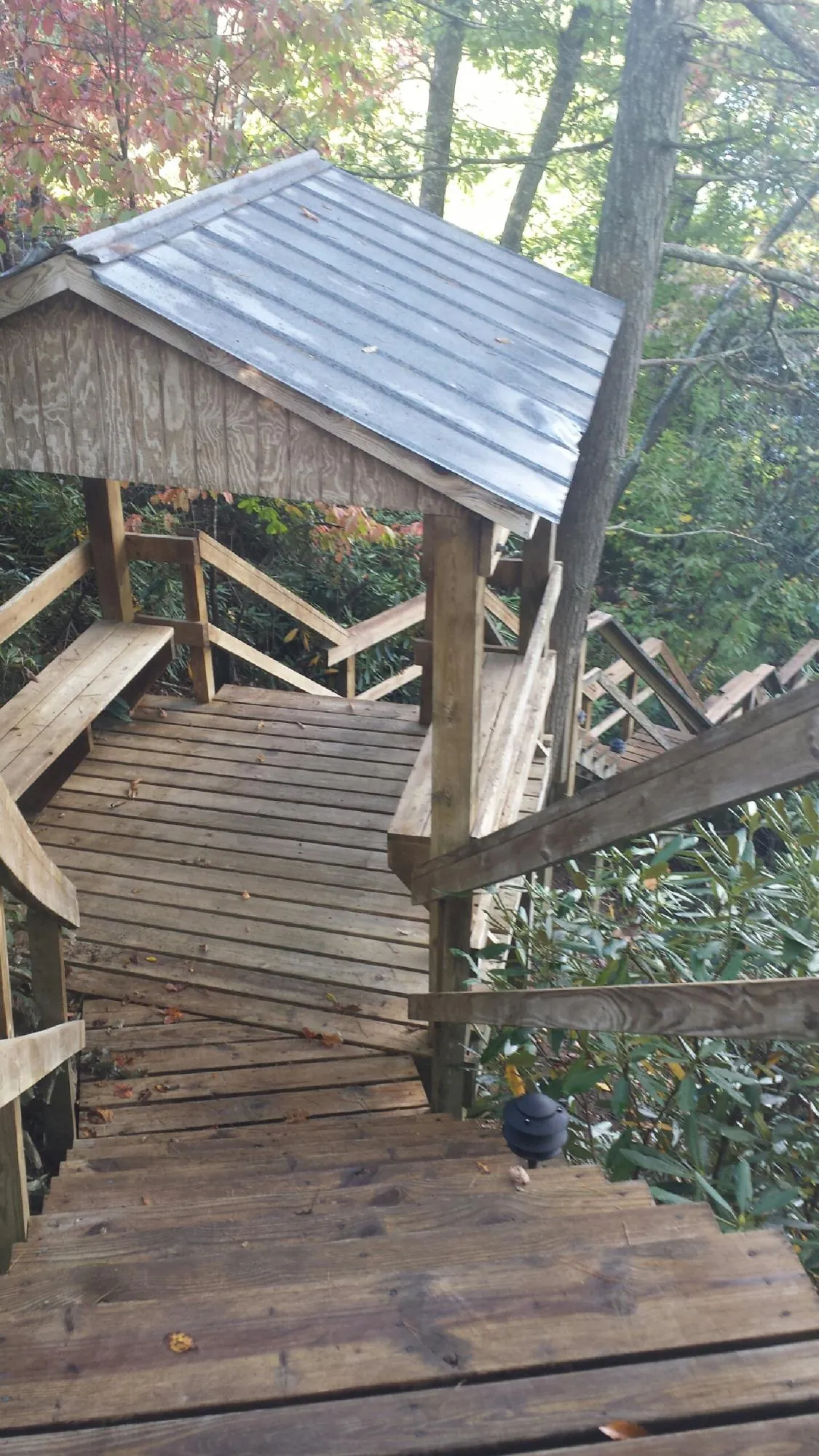 Metal roofed shelter over wooden steps on a wooded walkway — Skylight Repair & Installation work by our crew in Pope Army Airfield