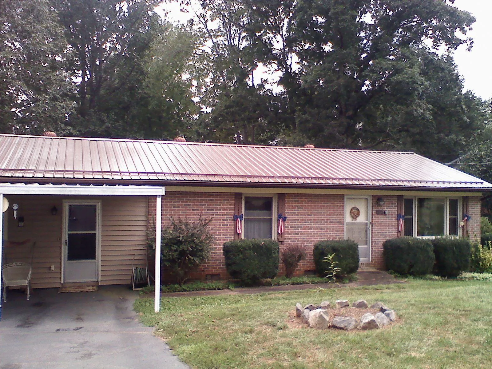 Bronze metal roof and carport on a brick ranch home — Roof Repair work by our crew in Pope Army Airfield