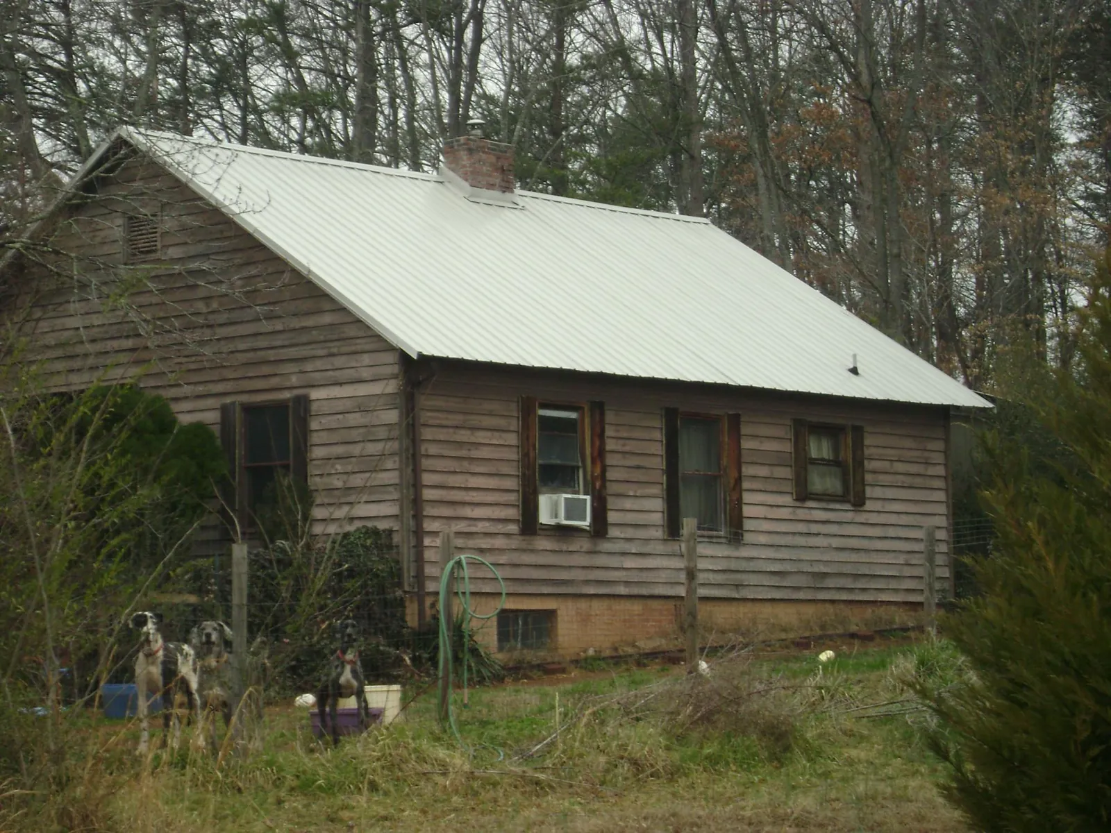 White metal roof on an old wood sided farmhouse, from a Asphalt Shingle Roof Repair job in Pope Army Airfield
